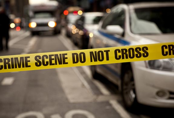 Police tape in front of police cars