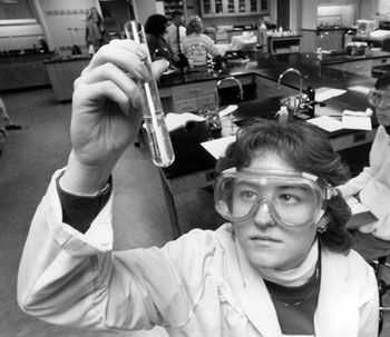 A woman holding up a test tube